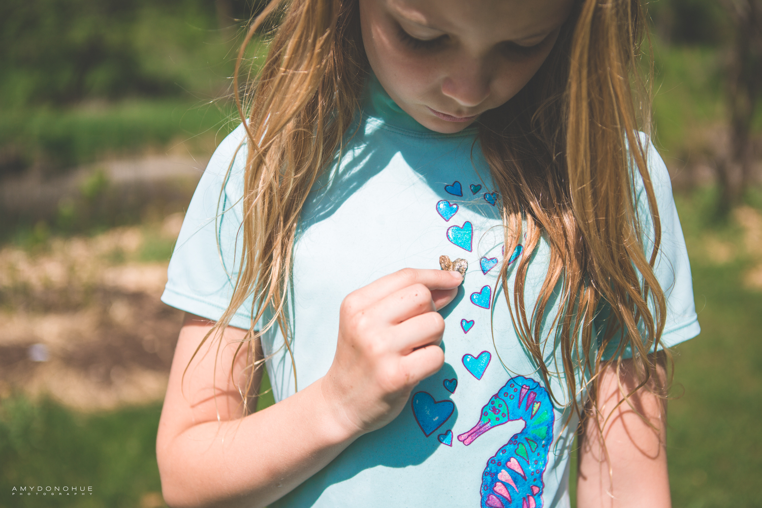 Little girl finding heart rocks.