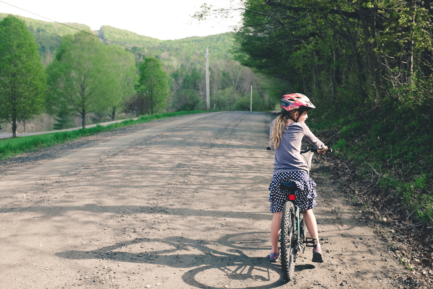 Little girl biking through the Vermont countryside.