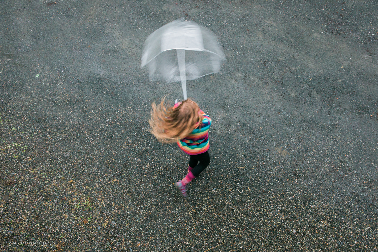 Little girl twirling in the rain.